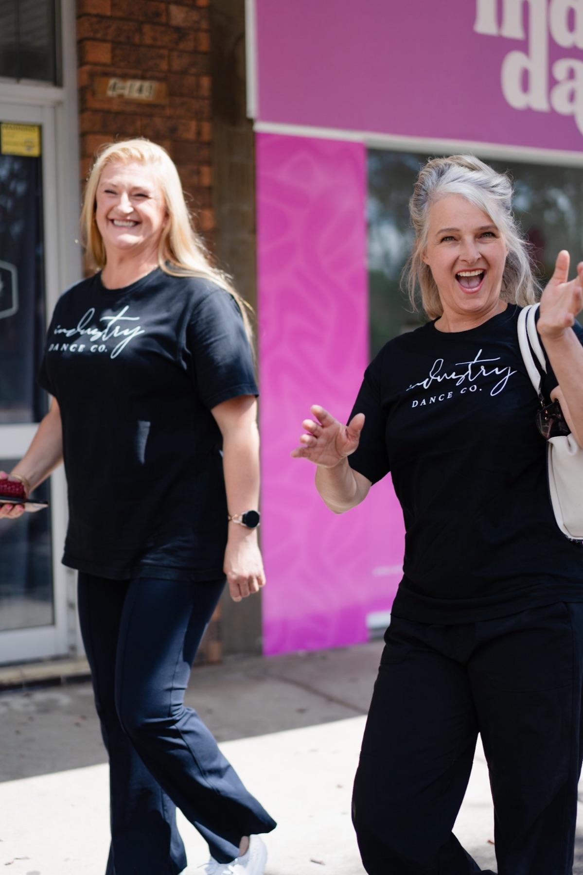 Two of the Industry Dance Co. family laughing outside the studio