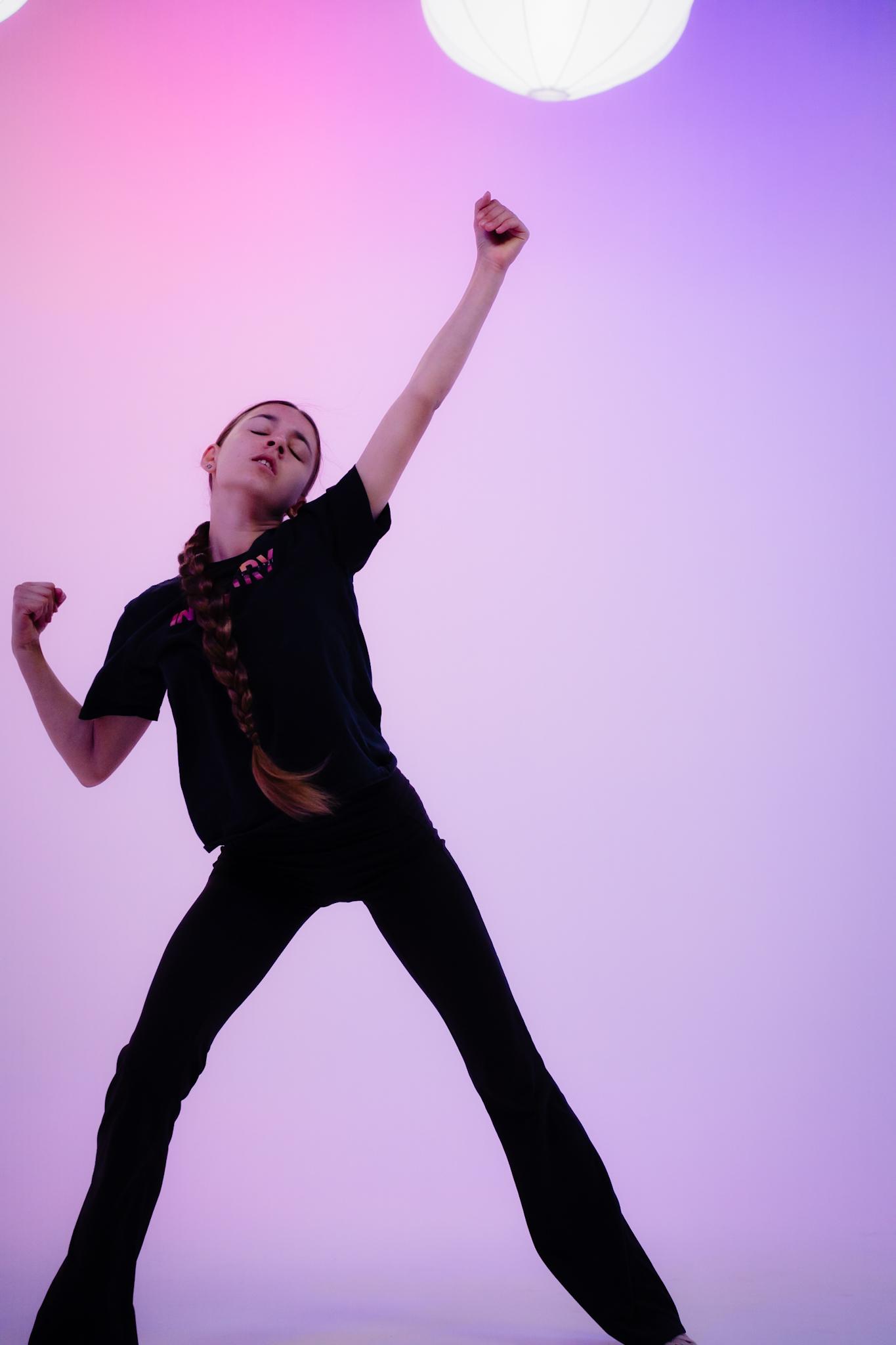 A dancer in black dancewear striking a pose