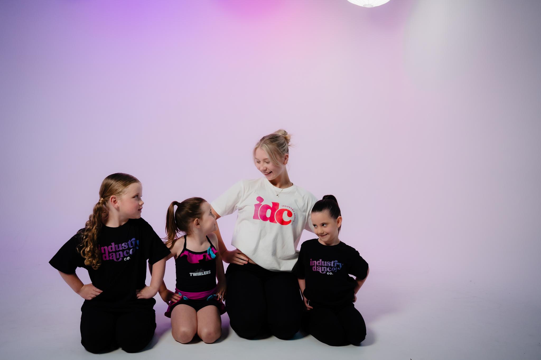 Young dancers and a teacher sitting together in the studio
